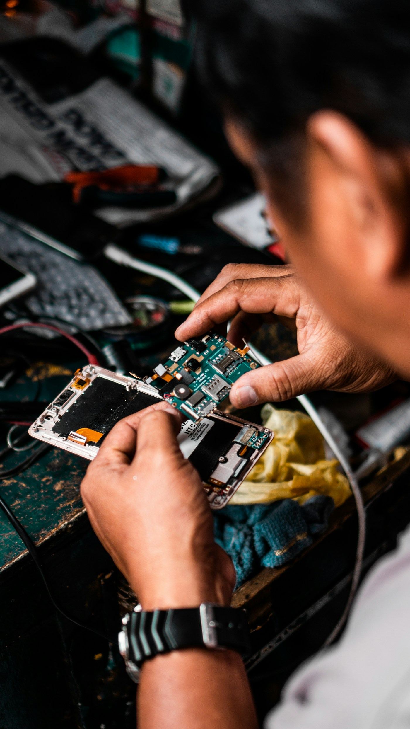 Technician dismantling electronic equipment for recycling